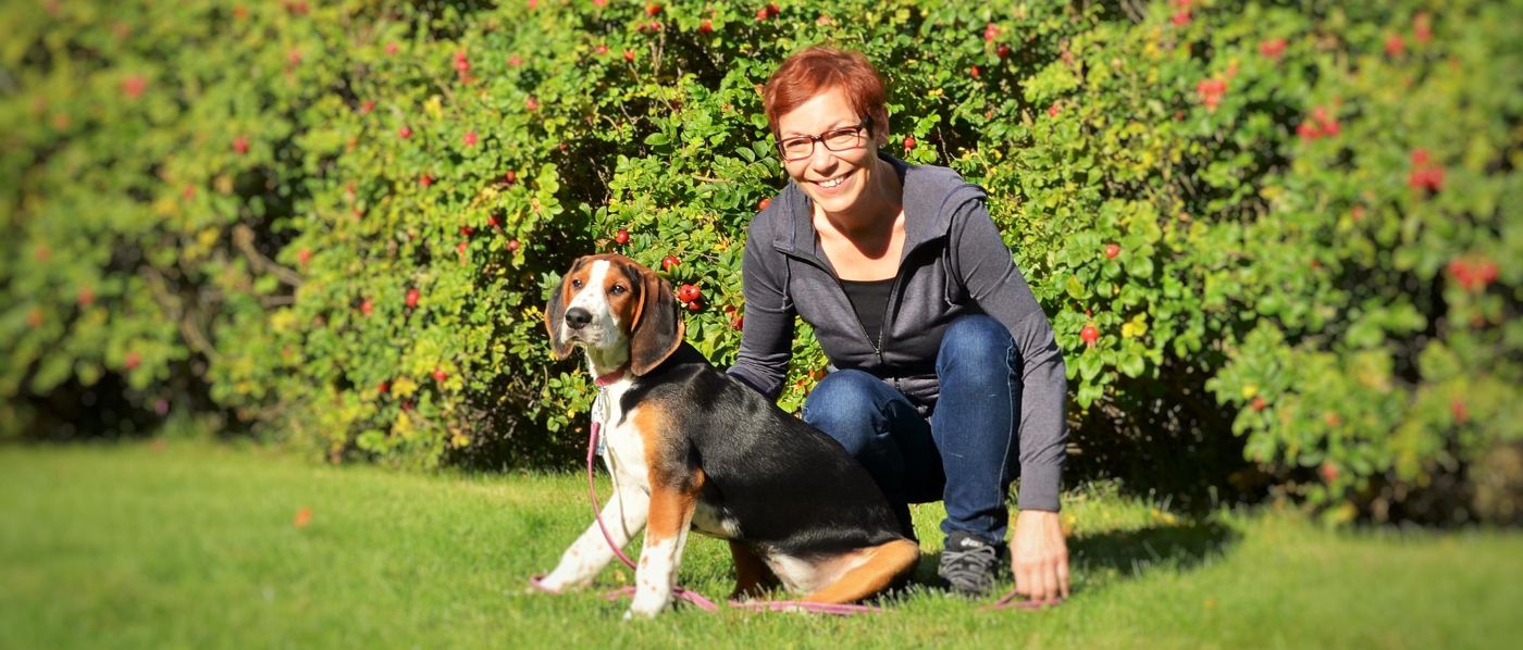 Leena Jokio koiran kanssa puutarhassa
